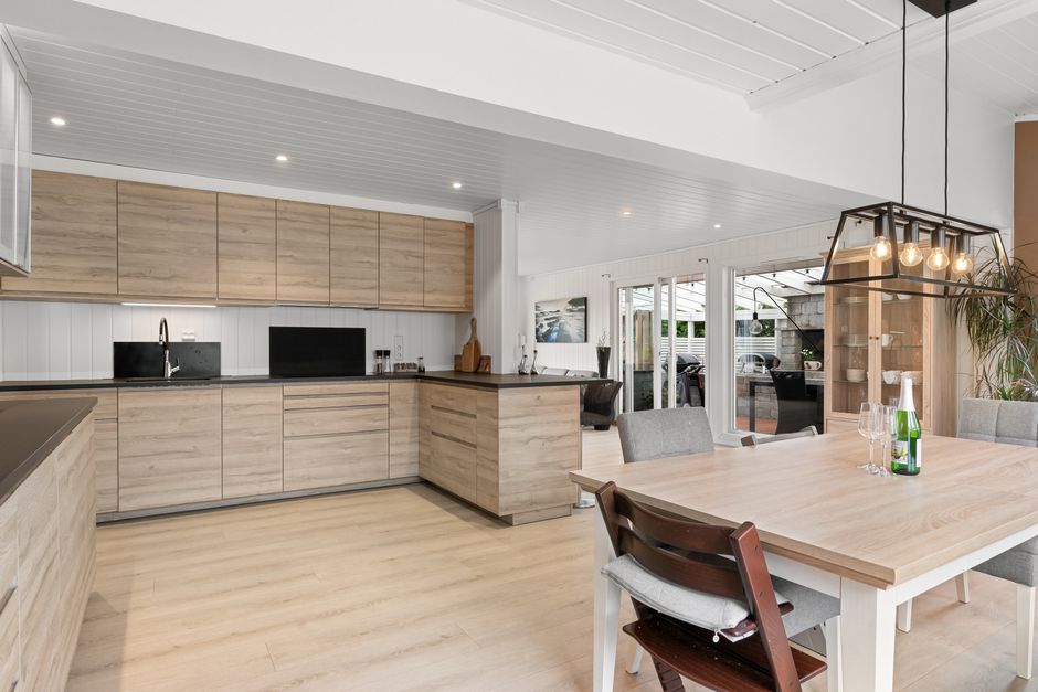 Elegant kitchen interior with wooden cabinets and dining area, perfect for modern living.